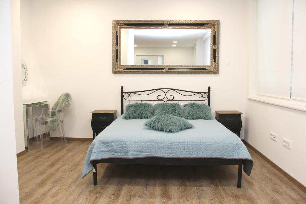 una camera da letto con un letto con uno specchio sul muro di Maja Apartment a Šibenik