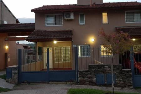 una casa con una puerta azul delante de ella en Duplex a mts del Rio con Aire Acond en Villa Carlos Paz