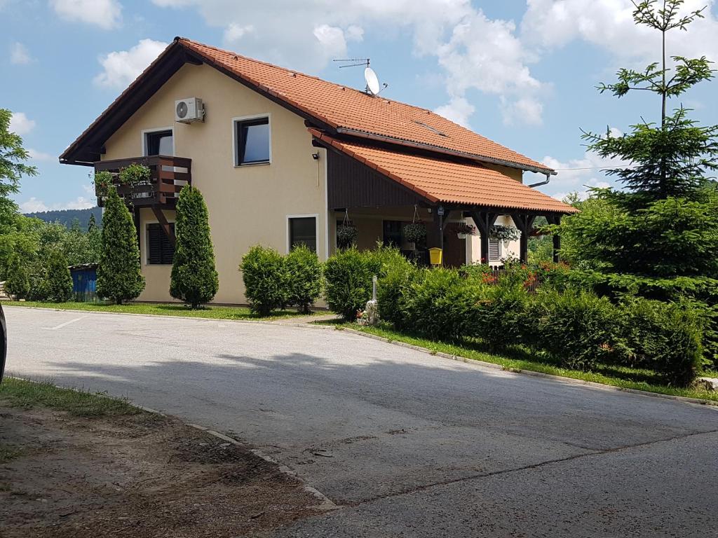 une maison avec un toit orange dans une rue dans l'établissement House Petra, à Rakovica