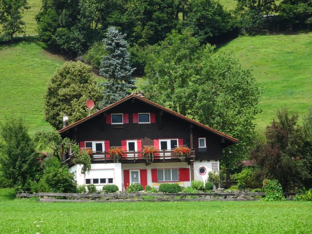 une maison rouge et blanche sur une colline dans l'établissement Ferienhaus in der Sonne, à Bad Hindelang