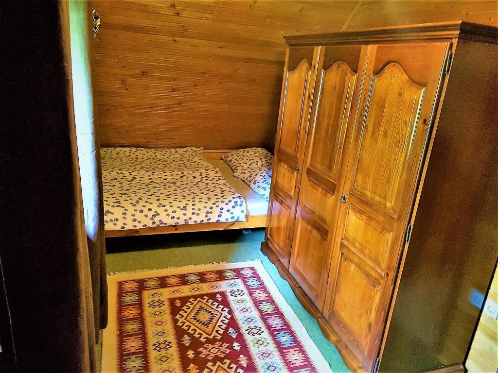 a small room with a bed and a wooden cabinet at Rogla - Chalet Mojca Pokrajculja in Zreče
