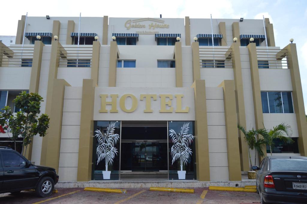 um hotel com carros estacionados em frente em Golden House Hotel & Convention Center em Santo Domingo