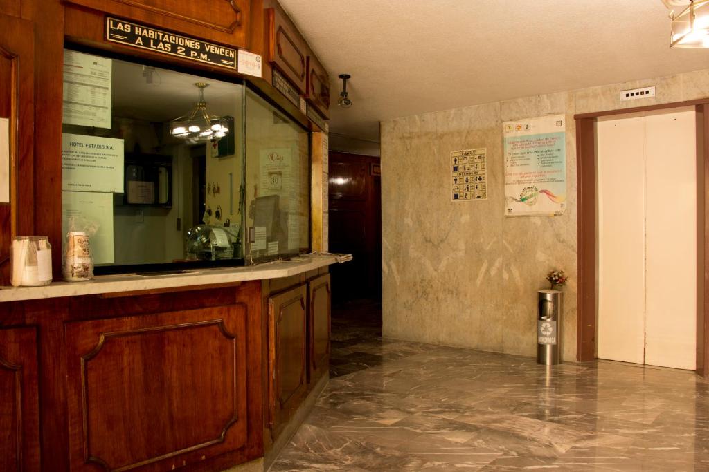 A wood-panelled service counter faces a marble-floored lobby with an elevator.