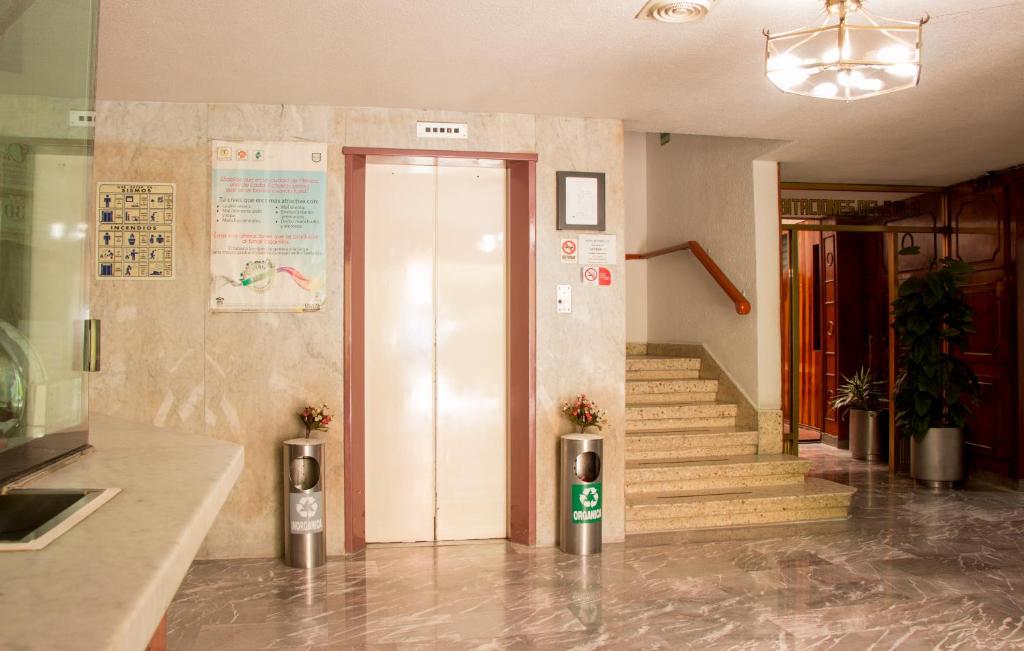 A polished lobby with an elevator, staircase, and visible reception counter edge.