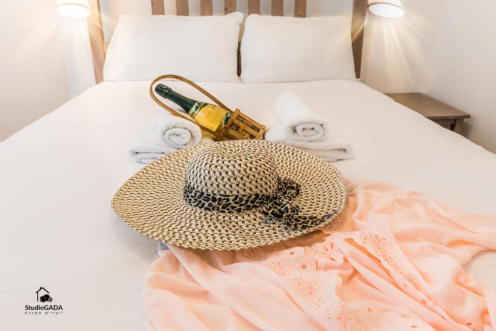 a hat and a bottle of champagne on a bed at Family Vacation by Lake Kinneret in Tiberias