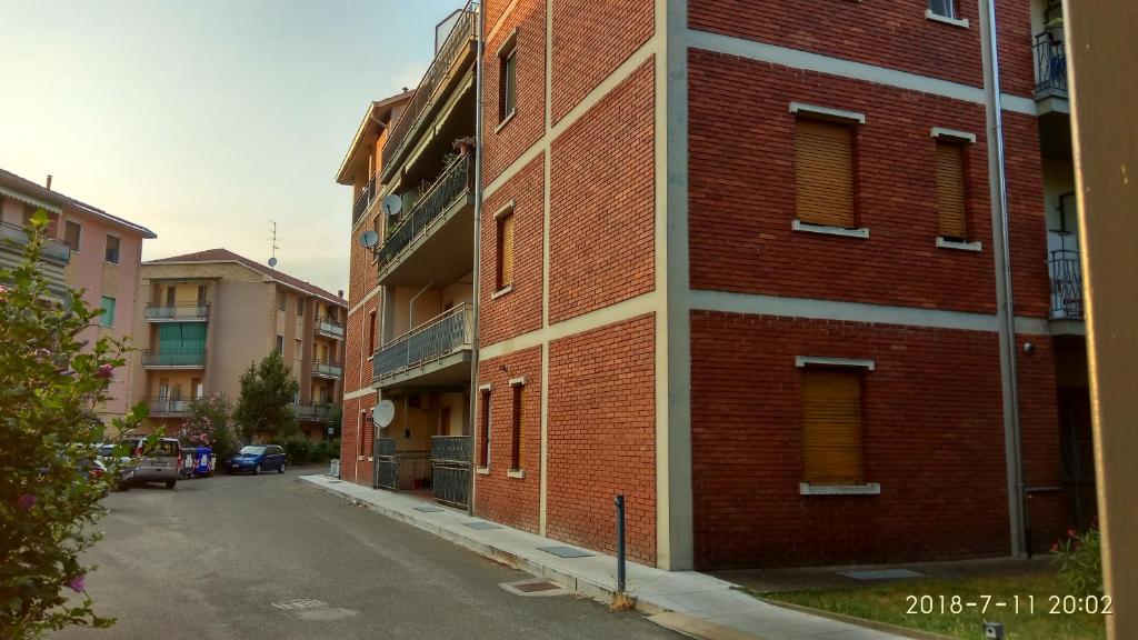 una calle vacía junto a un edificio de ladrillo rojo en Bixio, en Pavia