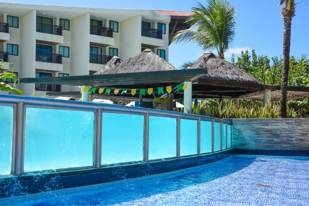 a swimming pool in front of a hotel at Marulhos Resort Porto De Galinhas in Porto De Galinhas