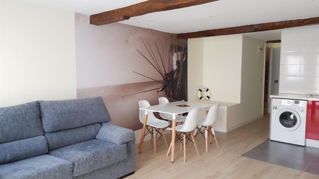 a living room with a couch and a table with chairs at Apartamentos-Bermeo in Bermeo