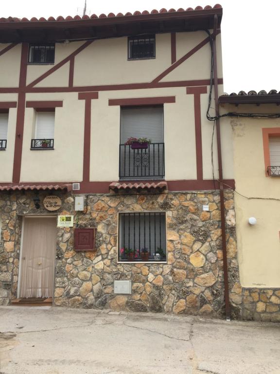 Edificio de piedra con ventana y balcón en El Rincon De Luna en Moratilla de los Meleros