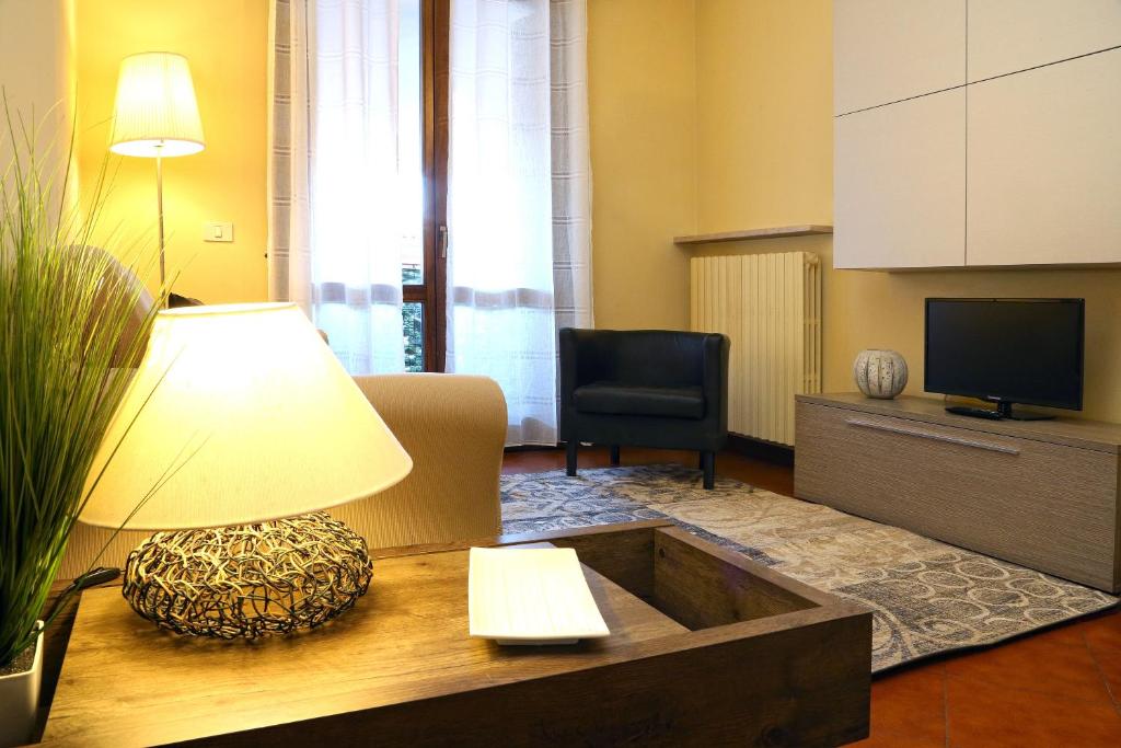 sala de estar con sofá y mesa con lámpara en Appartamenti Alighieri, en Bardolino