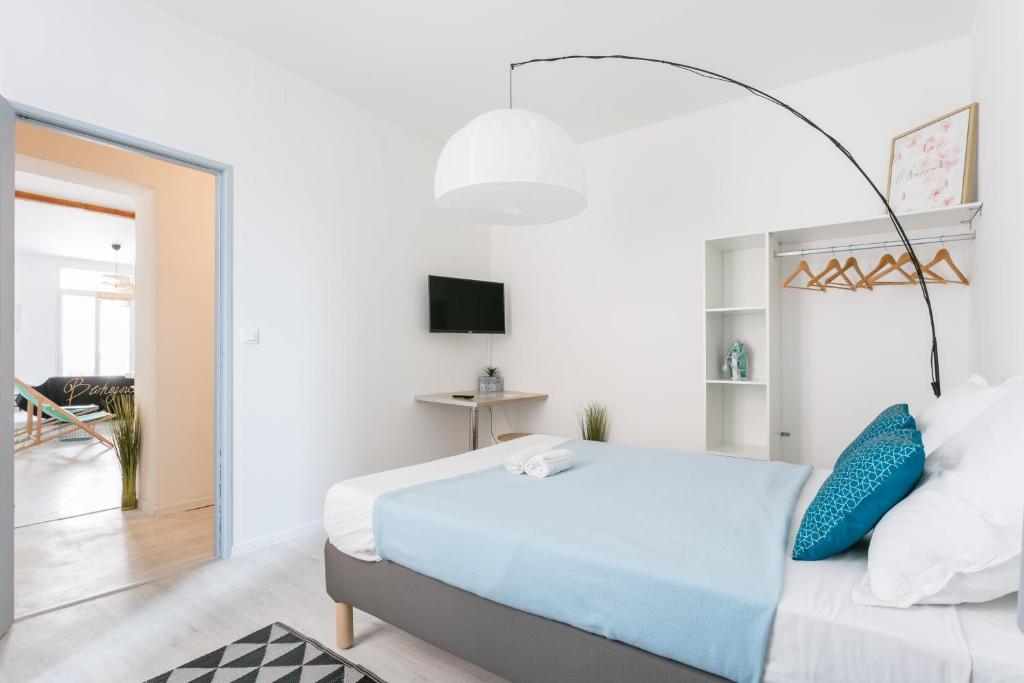 ein Schlafzimmer mit einem großen Bett mit blauen Kissen in der Unterkunft RELAXING 95m² DUPLEX APPARTEMENT 3 Chambres in Béziers