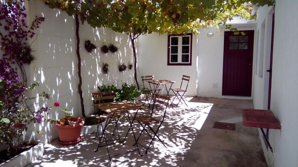 a patio with chairs and a table and some plants at Casa Sao Marcos in Figueira da Foz