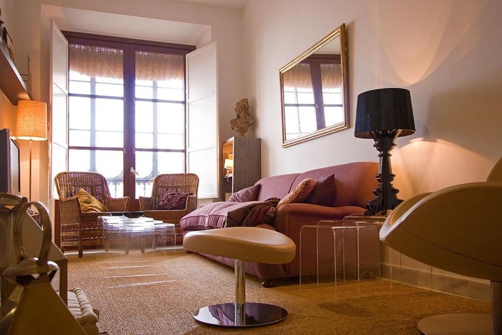 ein Wohnzimmer mit einem Sofa und einem Stuhl in der Unterkunft Toreros de Sevilla 5 pax in Sevilla