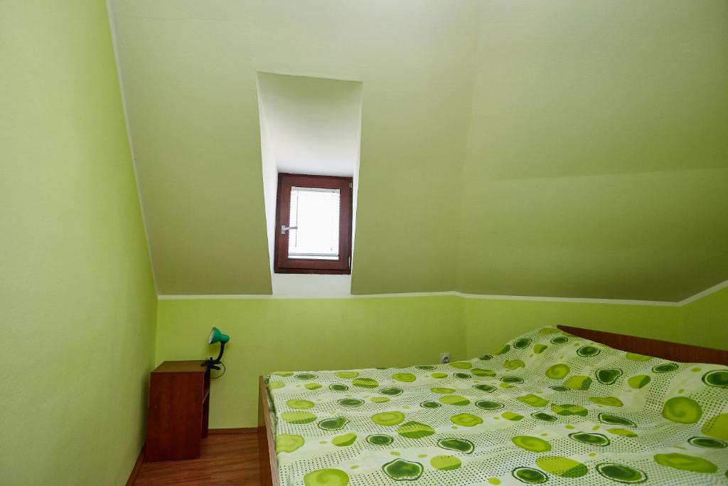 a green bedroom with a bed with a window at Apartmani Malica in Soko Banja