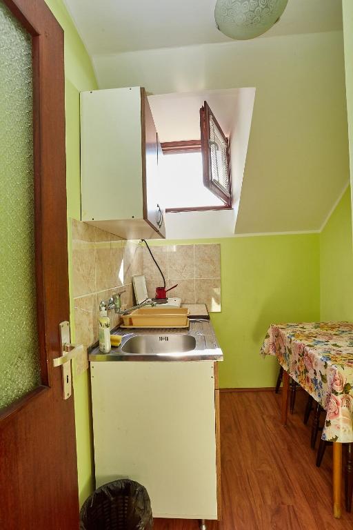 a small kitchen with a sink and a table at Apartmani Malica in Soko Banja