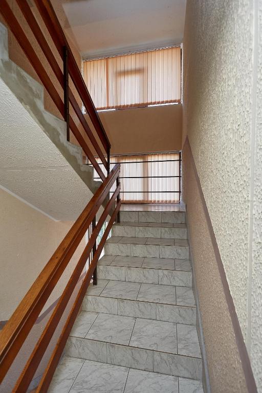 a staircase with wooden railings and a tile floor at Apartmani Malica in Soko Banja