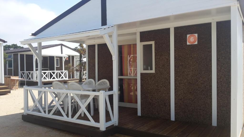 a building with white chairs on a deck at Parque de Campismo da Praia da Barra in Gafanha da Nazaré