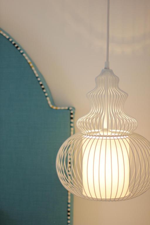 a light fixture hanging from a wall next to a chair at Il Borghetto Resort & Spa in Tropea