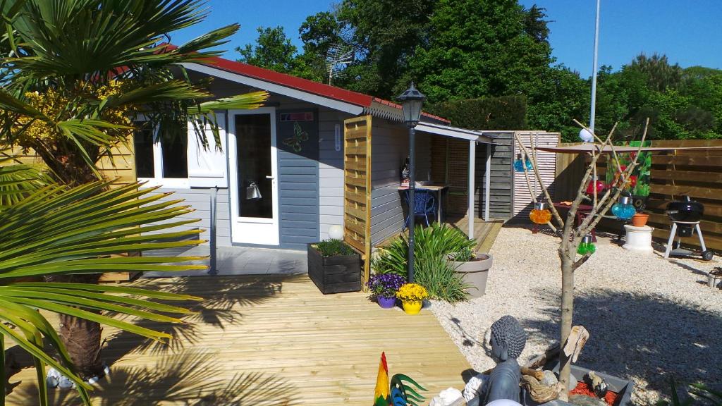 une petite maison avec une terrasse en bois devant elle dans l'établissement Casa Bihan Ty Coat, à Lannion