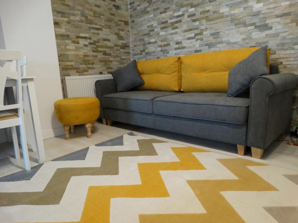 sala de estar con sofá y silla en Oni Venus Apartament en Cluj-Napoca