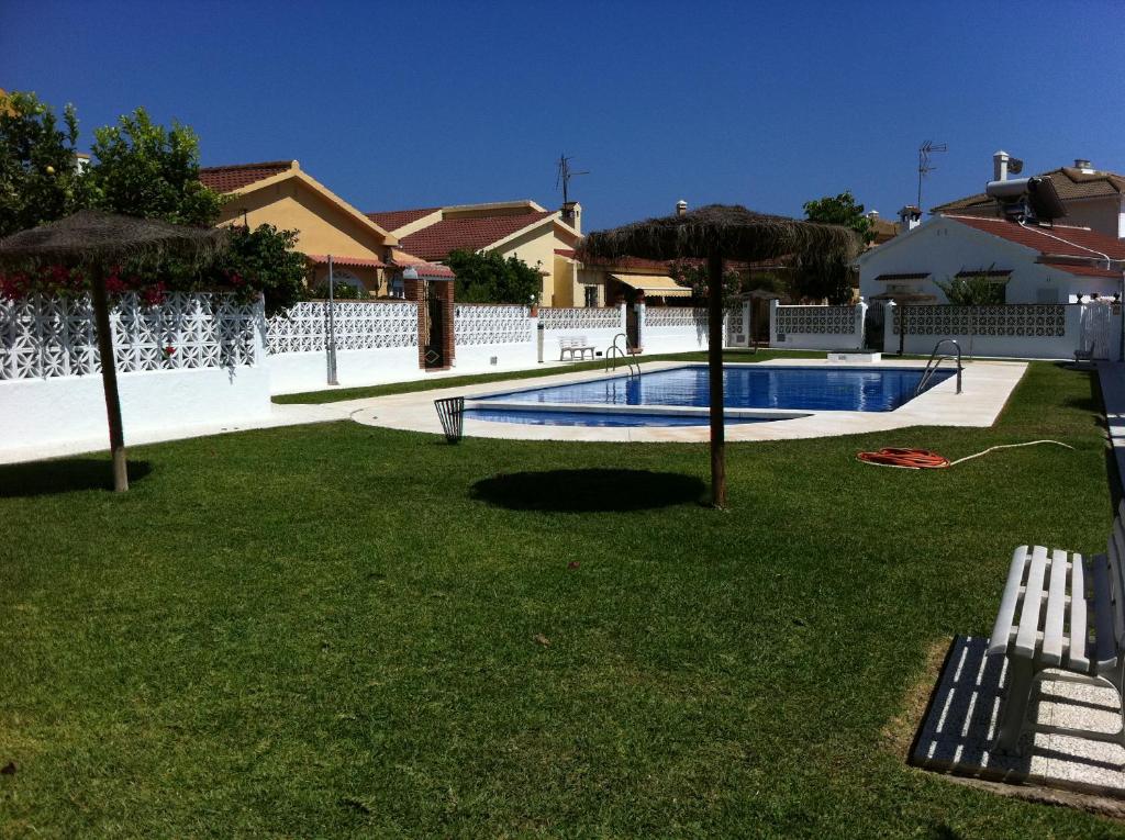 una piscina con 2 sombrillas en un patio en Los Alamos, en Torremolinos