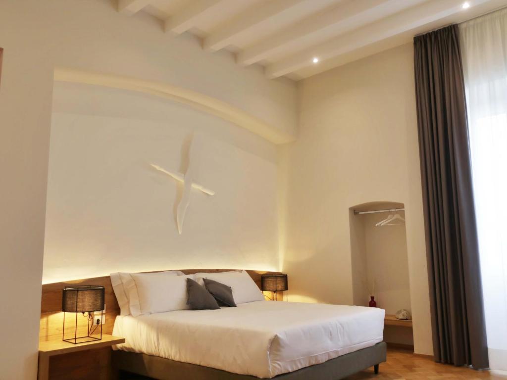 una camera con un letto bianco e un soffitto bianco di Palazzo Marina a Trani