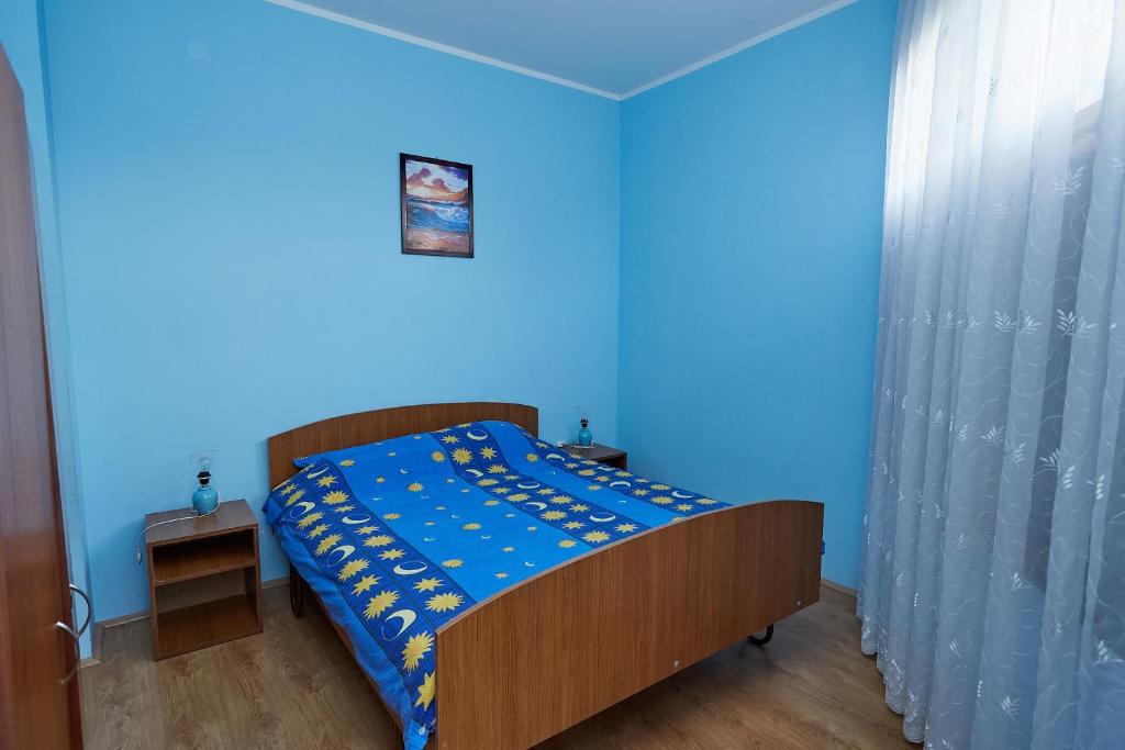 a blue bedroom with a bed with a blue wall at Apartmani Malica in Soko Banja