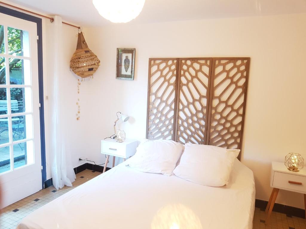 a bedroom with a white bed and a window at Villa Akwaba in Pyla-sur-Mer