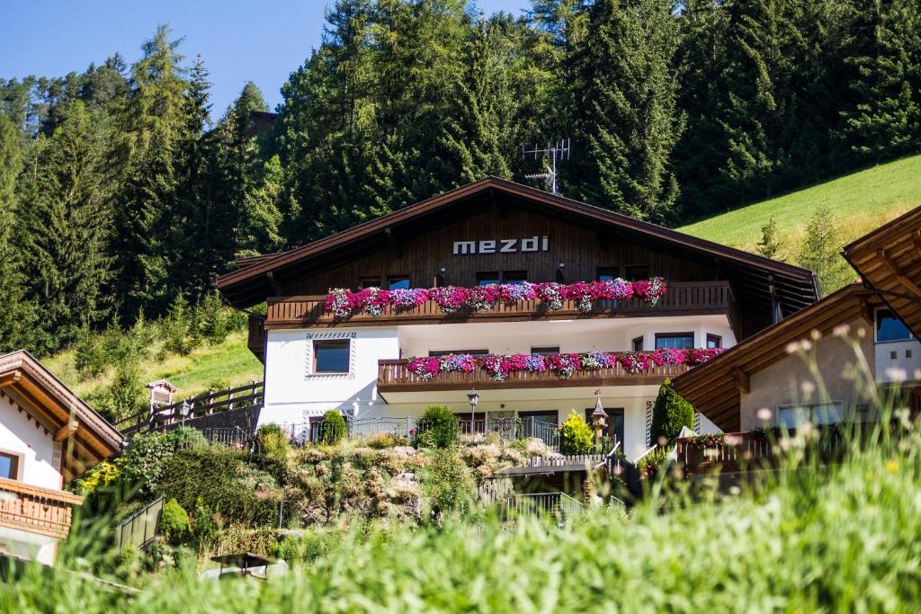 budynek z kwiatami na balkonie w obiekcie Apartments Mezdi w mieście Santa Cristina Valgardena