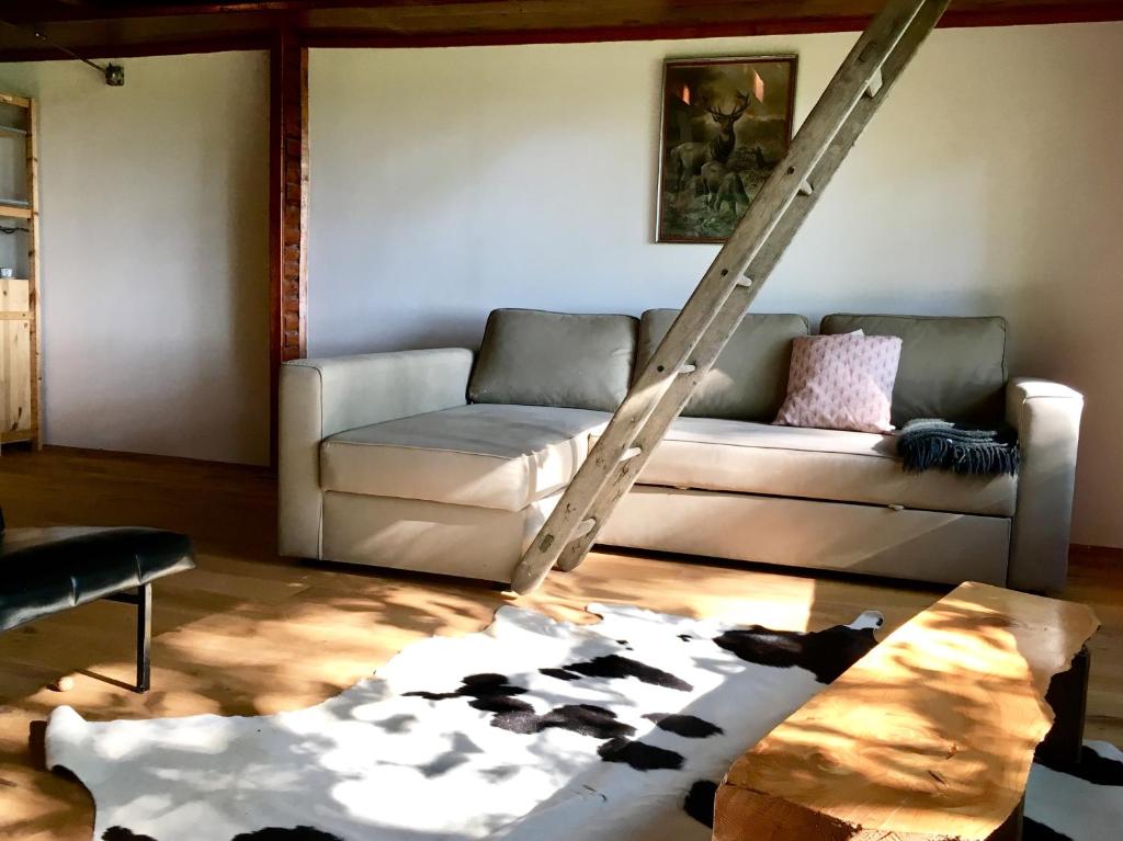 a living room with a couch and a cow rug at KÉSA Faház in Balatonlelle