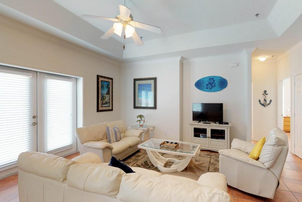 sala de estar con muebles blancos y ventilador de techo en Las Puertas 201 en South Padre Island