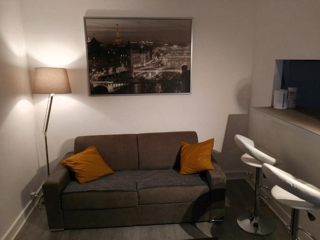 a living room with a couch and a picture on the wall at Comfy Parisian studio! in Ivry-sur-Seine