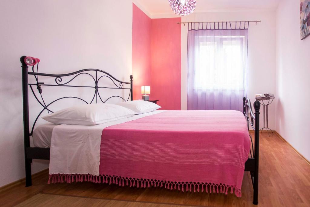 a bedroom with a large bed with a pink blanket at Apartment Beba in Rovinj
