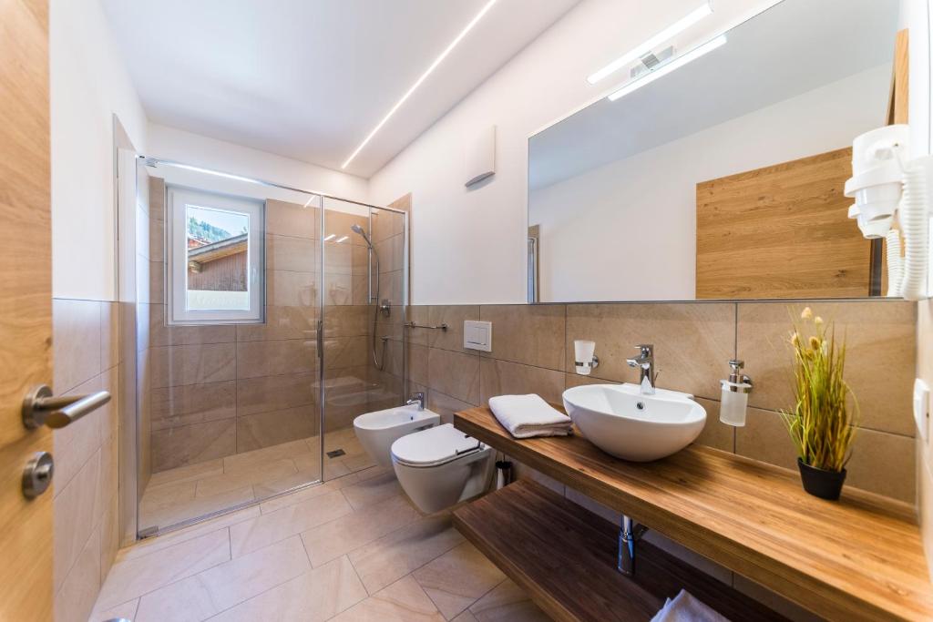 łazienka z umywalką, toaletą i prysznicem w obiekcie Apartments Mezdi w mieście Santa Cristina Valgardena