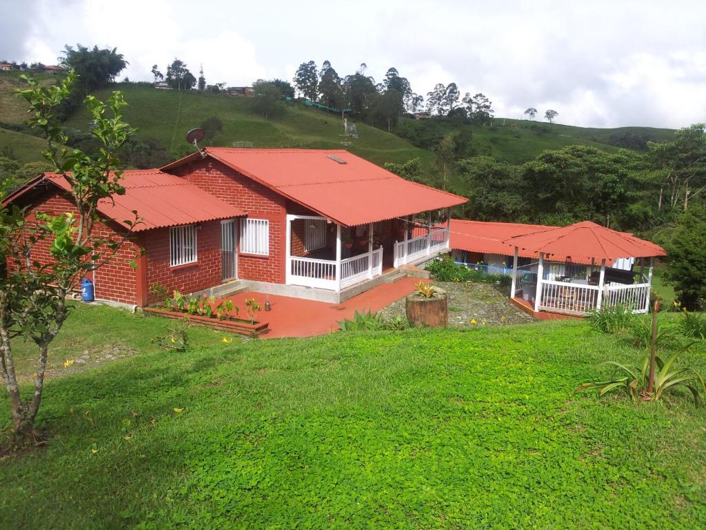 uma casa com um telhado vermelho numa colina em La Gaviota BnB em Filandia