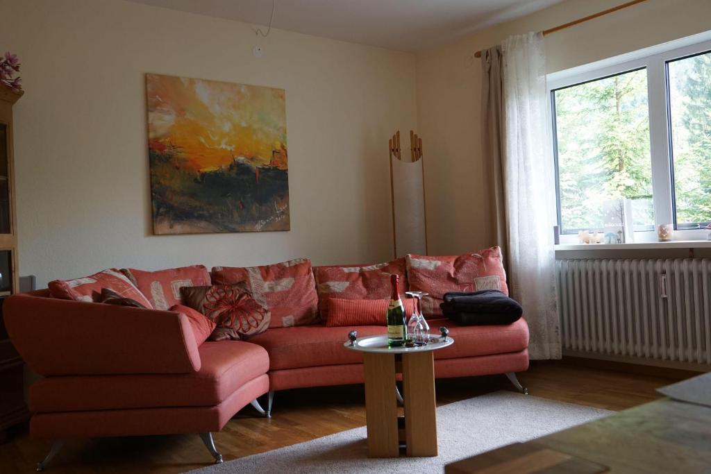 salon z czerwoną kanapą i stołem w obiekcie Ehlershus w mieście Reit im Winkl