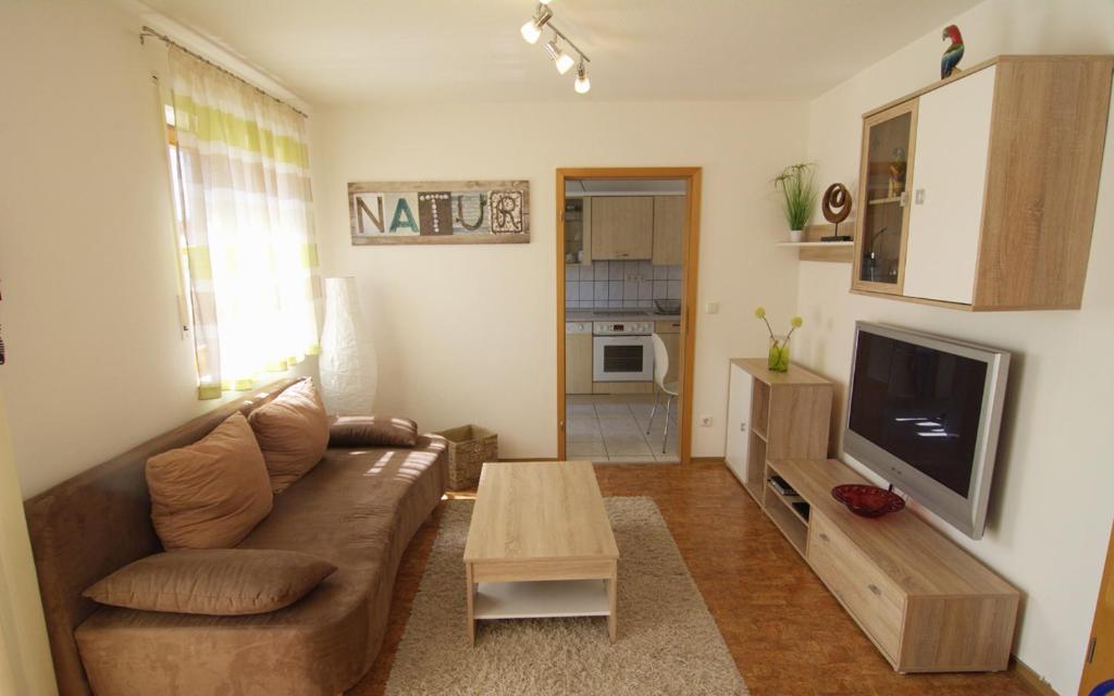 sala de estar con sofá, mesa y TV en Ferienwohnung Wagner Bayreuth en Bayreuth