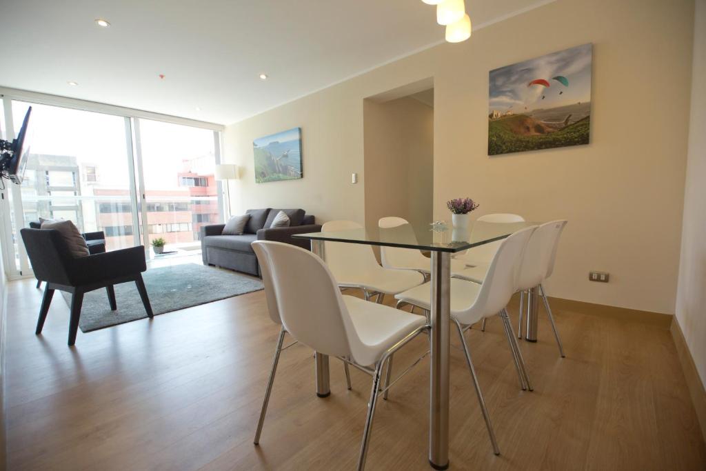 a living room with a dining room table and chairs at Urbano Apartments Miraflores Pardo in Lima