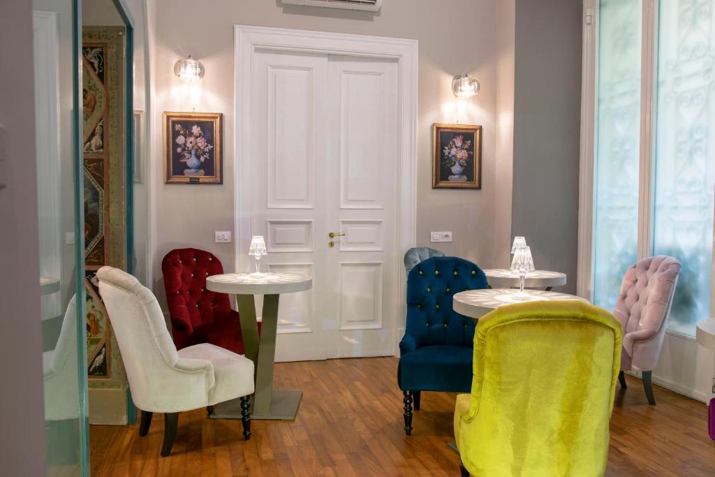 Habitación con sillas, mesa, mesa y sillas. en Leone Camere D'autore en Nápoles