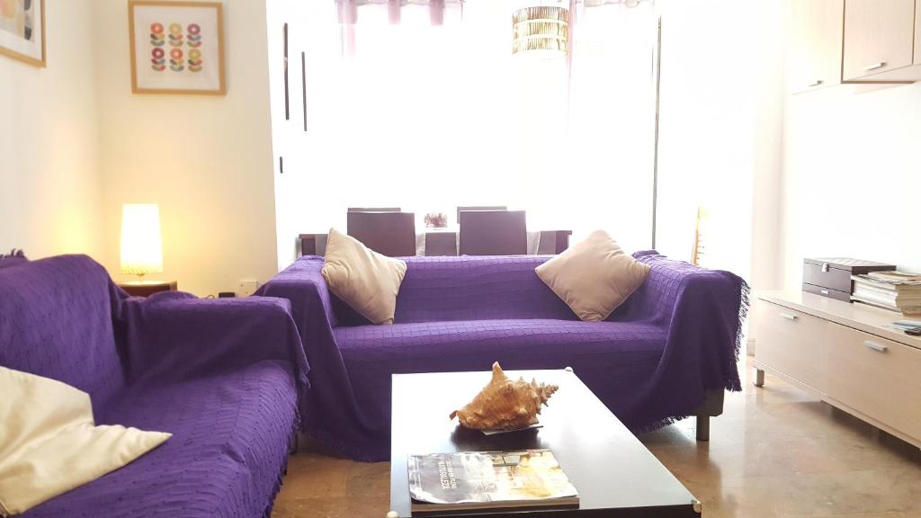 休達的住宿－Gran Vía flat，客厅配有紫色沙发和桌子