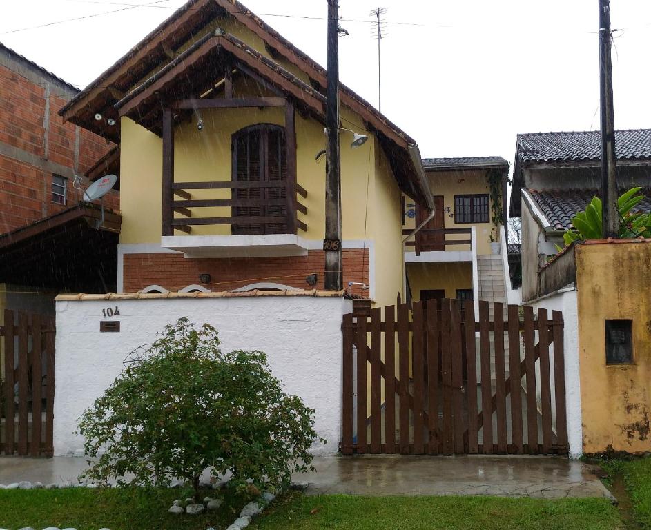 a house with a wooden gate and a fence at Casa Temporada Ubatuba in Ubatuba