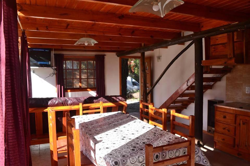 ein Esszimmer mit einem Tisch und einer Treppe in der Unterkunft Cabañas Paraiso Duplex 7 solo familias in Mar del Plata
