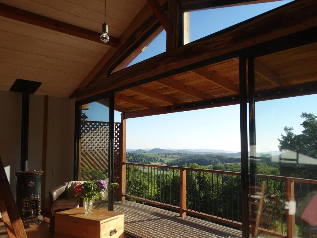 a screened in porch with a view of the mountains at Gite colombe des bois in Estadens