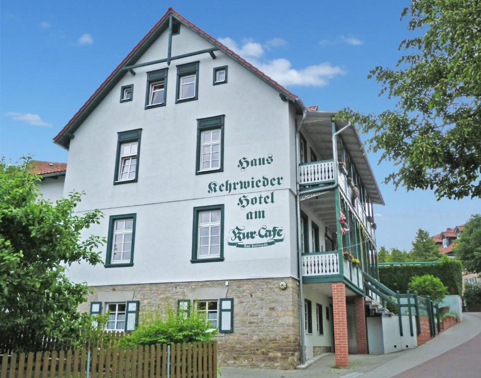 ein weißes Gebäude mit einem Schild an der Seite in der Unterkunft Haus Kehrwieder - Hotel am Kur-Café in Bad Suderode