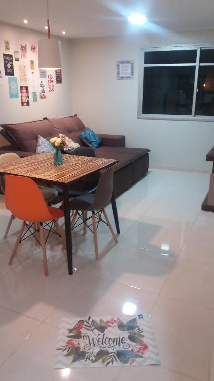 a living room with a wooden table and chairs at Apartamento Ed. Ouro Preto Praia do Morro in Guarapari