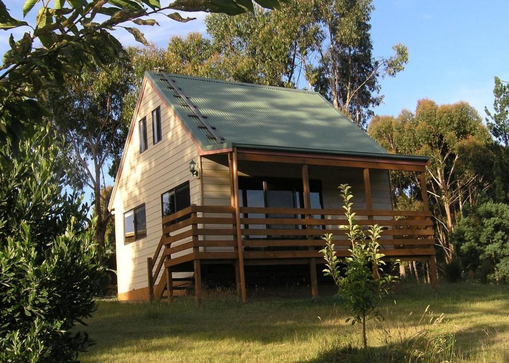 a small wooden cabin with a gambrel roof at Carinya Park in Gembrook