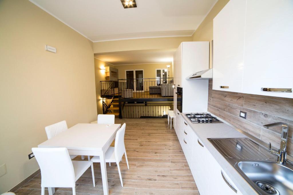 eine Küche mit weißen Schränken sowie einem Tisch und Stühlen in der Unterkunft SUNSET LOFT in Milazzo