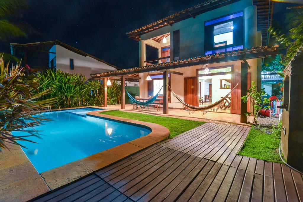 a house with a swimming pool in front of a house at Casa Sapoti - 5 minutos a pé da praia in Praia do Forte