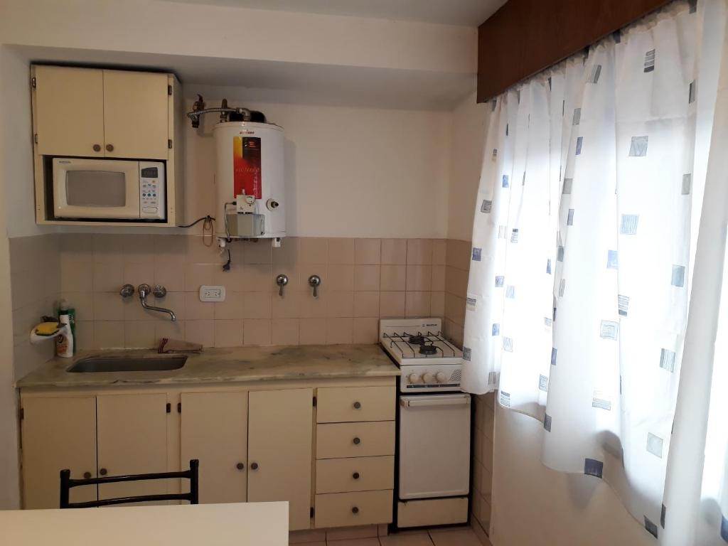 una pequeña cocina con fregadero y microondas en Departamento ideal I! en Villa María