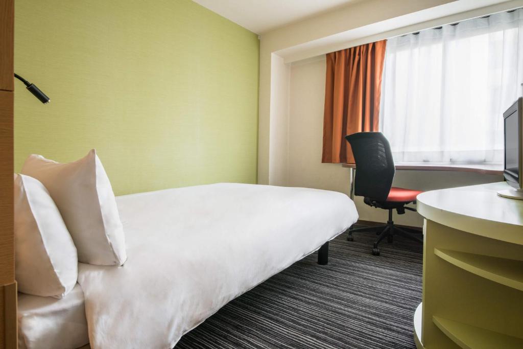 a hotel room with a bed and a desk at the b ikebukuro in Tokyo